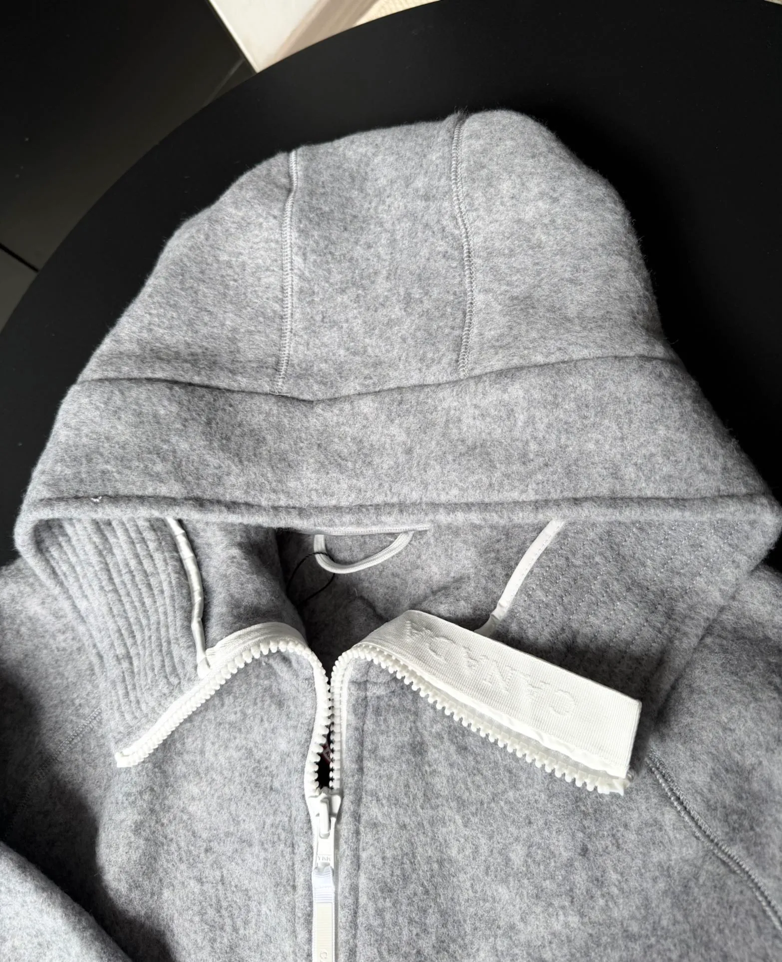 P660 Canada Goose Fleece Wool Badge Hooded Jacket Fabric selection: Wool fleece fabric blended with wool as the main body and a very small amount of spandex and polyester fiber. Wool is a core natural ingredient that provides unparalleled temperature regulation, antibacterial and anti-odor properties and a skin-friendly feel. The feeding of a small amount of spandex gives the fabric a certain degree of four-way elasticity, making it non-restrictive during daily activities. As the basis of fleece's structure, polyester fiber enhances the fabric's durability, wrinkle resistance and quick-drying properties. It contributes to the loft of the fleece and provides functions such as trapping air.  Detail 1: The sleeves and hem are closed with 2×2 ribbing. Its strong elasticity can closely fit wrists and waists of different thicknesses, forming an effective 'seal' to prevent cold wind from blowing back. It can still maintain its original shape after repeated stretching and use, and is not easy to loose and deform. And the ribbed cuffs can convey a sense of design and enhance the visual beauty.  Detail 2: The combination of hood design and elastic buckle improves warmth and windproof performance when wearing. Accessories: Customized elastic drawstring, elastic buckle, custom zipper pendant, custom armband Size: S M L Color: black gray coffee rice pink